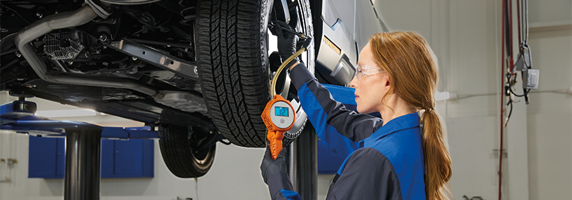 A Subaru technician checking tire pressure. | Landers McLarty Subaru in Huntsville AL