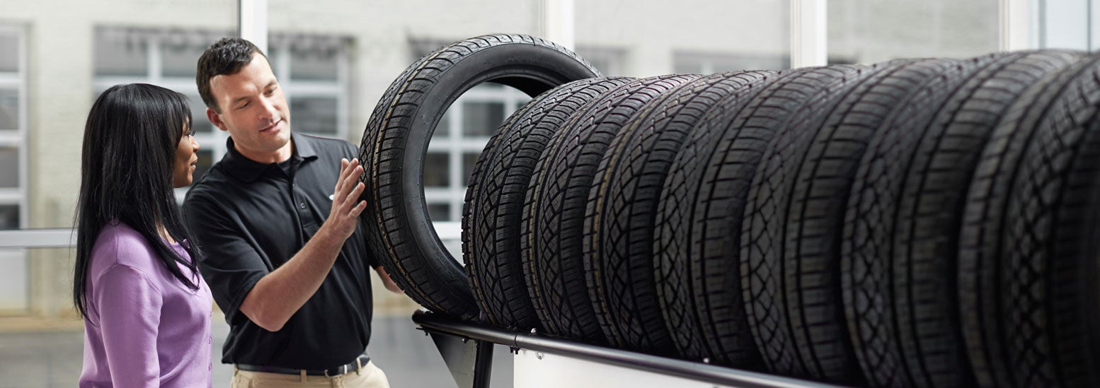 Subaru service representative showing customer a tire. | Landers McLarty Subaru in Huntsville AL